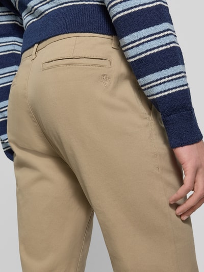 Männermodel trägt schmale Chino mit gerader Silhouette und mittlerer Bundhöhe von REVIEW, beige, Baumwoll-Elasthan-Mix, Nahaufnahme Rückansicht