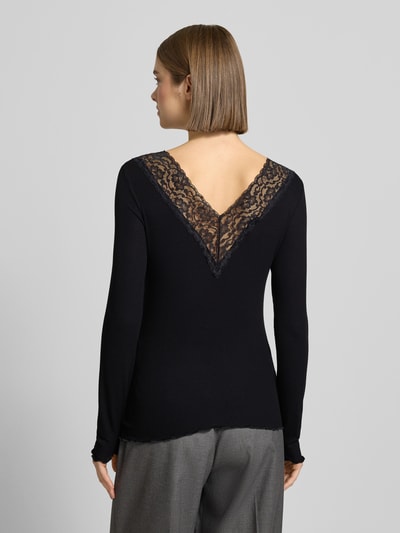 Vrouwenmodel draagt Shirt met lange mouwen van viscosemix met stretch, effen design, met kant en V-hals Model 'SIRI' van PIECES, nauwsluitend model. Ganzkörperansicht Rückansicht.