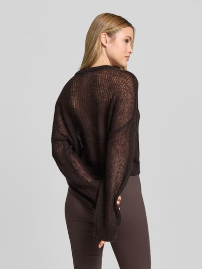 Frauenmodel trägt sommerlichen cropped Strickpullover - curated by Mary Braun von Style Icon Collection in Braun mit Strick-Optik, Relaxed-Fit, Rundhalsausschnitt und elastischen Abschlüssen, Rückenlänge bei Größe S: 53 cm, Ärmellänge bei Größe S: 72 cm, Ganzkörperansicht Rückansicht.