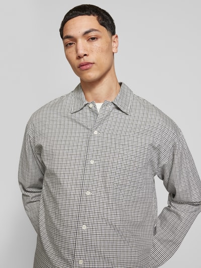 Männermodel trägt Regular Fit Freizeithemd aus Baumwolle Modell 'AUSTIN' von Jack & Jones, feines Karo-Muster, Nahaufnahme Oberkörper.