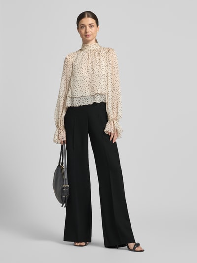 Modelka nosi Weite Hose mit Bügelfalten Modell 'NANTES' od MAX&Co., czarny kolor, krój regular fit, wide leg, wysoki stan, przód z zakładkami, klasyczna elegancja, zdjęcie całej sylwetki z przodu.