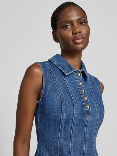 Frauenmodel trägt Minikleid in Denim-Optik von Self-Portrait aus Baumwoll-Mix, taillierte Passform, Umlegekragen, ärmelloses Design, Nahaufnahme Oberkörper.