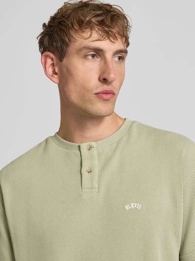 Männermodel trägt Henley-Shirt mit Strukturmuster und Label-Stitching von BLKVIS, Reine Baumwolle, Regular-Fit, Nahaufnahme Oberkörper.
