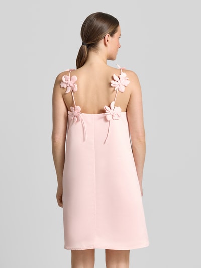Kobiece model prezentuje Cocktailkleid mit floralen Applikationen Modell 'DOUCE' od YAS, jasnoróżowy, rozkloszowany krój, minisuienka, cienkie ramiączka z kwiatowymi aplikacjami, długość tyłu w rozmiarze 36: 65 cm, szerokość w rozmiarze 36: 43 cm, widok całej sylwetki od tyłu.