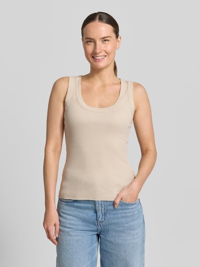 Modelka kobieca ma na sobie Tanktop z okrągłym dekoltem model 'TAVIRA' od Drykorn, beżowy, wykonany z czystej bawełny, krój slim fit, dzianina o drobnym prążku, długość pleców w rozmiarze S: 41 cm, widok całej sylwetki z przodu.