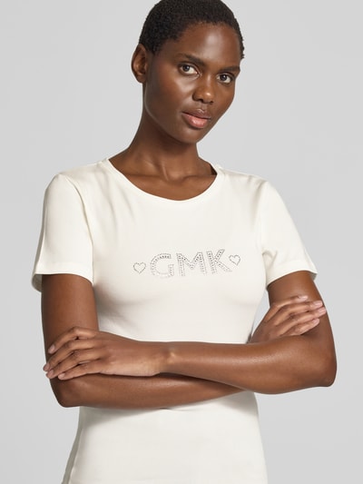 Vrouwenmodel draagt T-shirt met siersteentjes model 'Shelly' van GUIDO MARIA KRETSCHMER WOMAN, materiaalmix met stretch, slim fit, ronde hals, ruglengte maat 36 59 cm, nahaufnahme bovenlichaam.