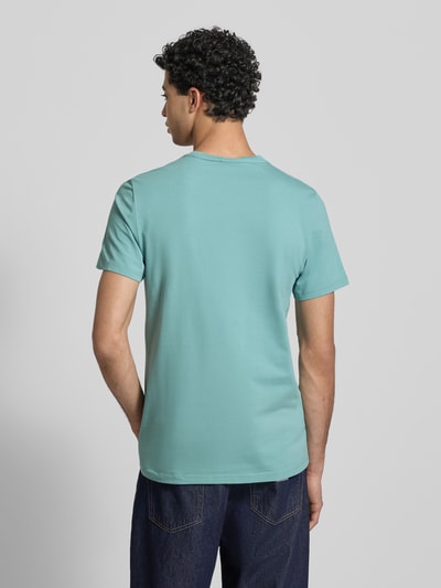 Männermodel trägt Slim Fit T-Shirt mit Logo-Stitching von G-Star Raw in Türkis, glatte Textur, Rundhalsausschnitt, Ganzkörperansicht Rückansicht.