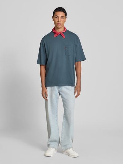 Männermodel trägt Regular Fit T-Shirt aus reiner Baumwolle von Levi's®, dunkelblau, kombiniert mit heller Jeans, Ganzkörperansicht von vorne.