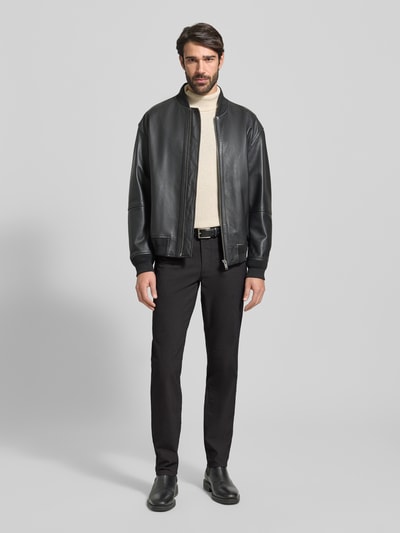 Männermodel trägt Stoffhose mit 5-Pocket-Design Modell 'Cadiz' von Brax in Schwarz, Baumwoll-Mix mit Stretch-Anteil, Gerader Schnitt, Ganzkörperansicht von vorne.