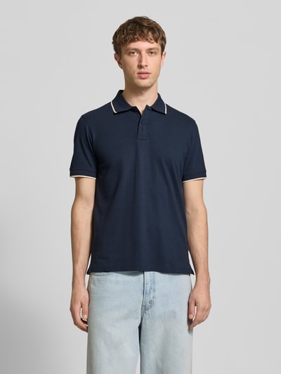 Männermodel trägt Regular Fit Poloshirt mit Logo-Stitching Modell 'Hedin' von Blend in Dunkelblau, kurzärmelig, Baumwolle, Ganzkörperansicht von vorne.