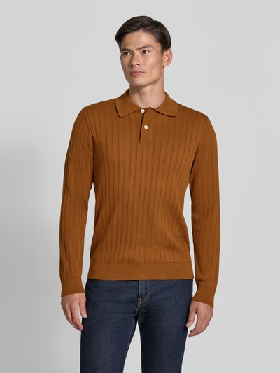 Männermodel trägt Regular Fit Poloshirt aus reiner Baumwolle Modell 'TORINO' von Selected in Braun mit feinem Rippstrick, Ganzkörperansicht von vorne.