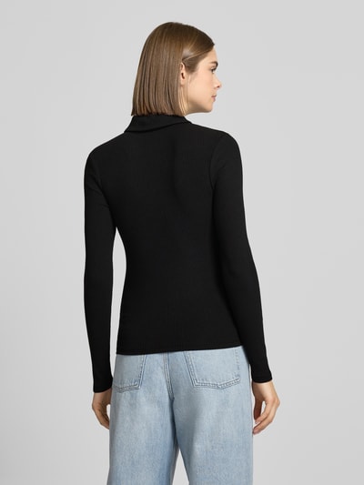 Vrouwenmodel draagt Slim Fit Langarmshirt uit katoenmix model 'KITTE' van Pieces, zwart, ribtextuur, polokraag, detailstiksel, unilook. Volledig lichaam van achteren.