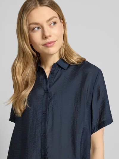 Frauenmodel trägt Relaxed Fit Bluse aus Modal-Mix mit Seiden-Anteil Modell 'MINA' von Samsøe Samsøe, dunkelblau glänzend, Nahaufnahme Oberkörper. Rückenlänge 62 cm, 1/2-Arm, Hemdblusenkragen.