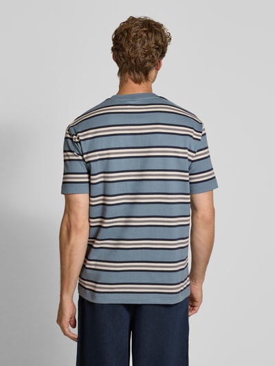 Männermodel trägt Relaxed Fit T-Shirt aus reiner Baumwolle Modell 'ESS ELEVATED' von Marc O'Polo, blau-weiß geringelt, Ganzkörperansicht Rückansicht. Herren T-Shirt von Marc O'Polo.