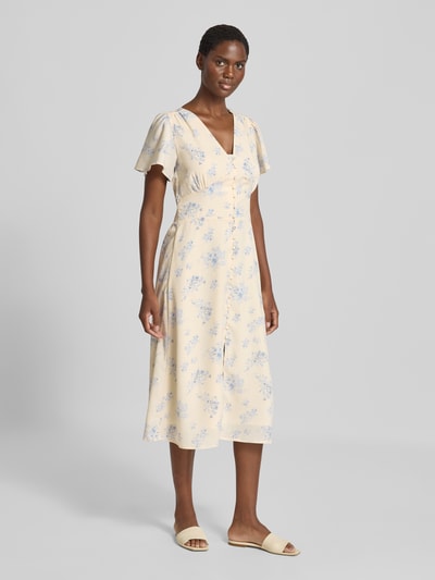 Frauenmodel trägt Midikleid mit Knopfleiste Modell 'Eleni' von Neo Noir in hellgelb mit blauem Allover-Print, A-Linie, Ganzkörperansicht von vorne.