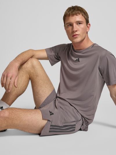 Männermodel trägt Regular Fit T-shirt met logoprint model 'Power' van adidas Training in grijs, ronde hals, ruglengte maat M 65 cm, Nahaufnahme Oberkörper.