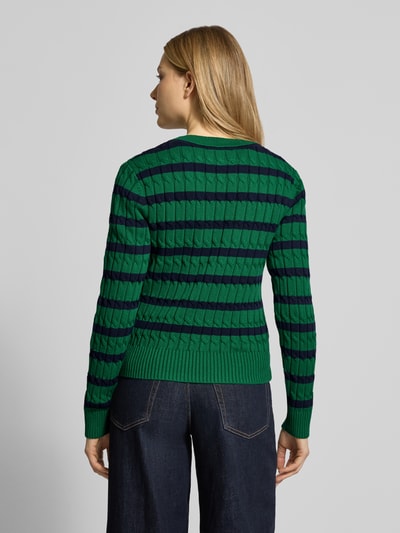 Frauenmodel trägt Slim Fit Strickpullover aus reiner Baumwolle von Tommy Hilfiger in grün-blauem Streifenmuster, gerippte Bündchen, ganzkörperansicht Rückansicht.