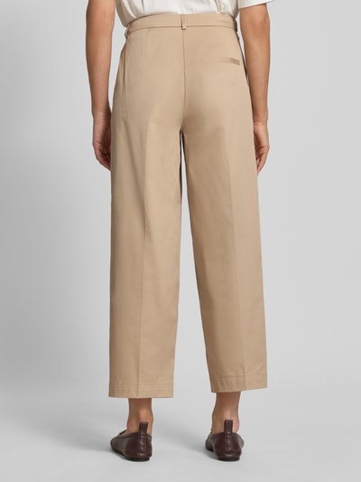 Frauenmodel trägt Hose mit Falten und Gesäßtasche von Rich & Royal aus Baumwoll-Elasthan-Mix in Beige, Wide Leg, Ganzkörperansicht Rückansicht.