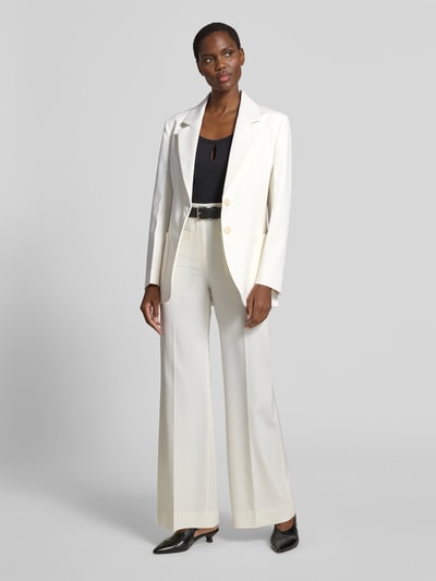 Frauenmodel trägt Blazer aus Woll-Mix mit Brusttasche von Victoria Beckham, cremefarben, taillierte Passform, Ganzkörperansicht von vorne.