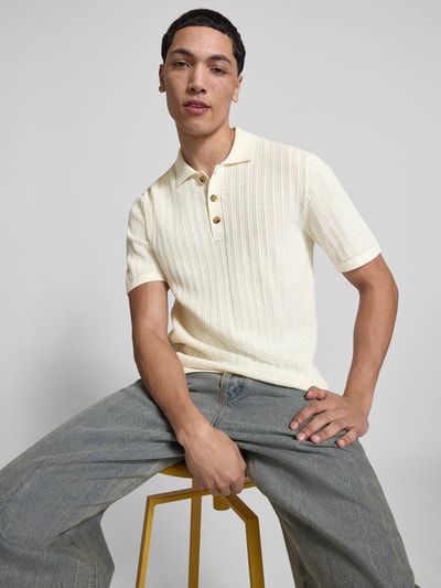 Männermodel trägt Regular Fit Poloshirt aus Baumwoll-Mix Modell 'MOON' von Only & Sons in cremefarbener Strickoptik, Nahaufnahme Oberkörper.