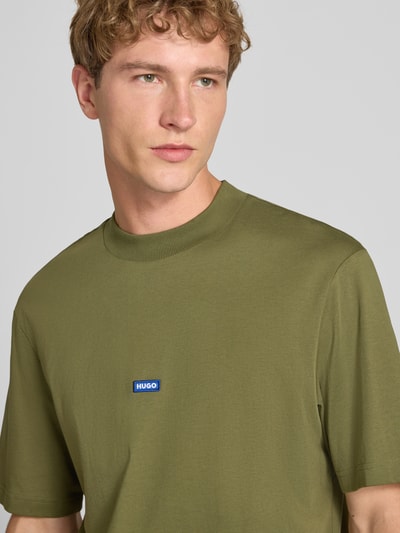 Mężczyzna nosi Męski t-shirt Regular Fit T-Shirt aus reiner Baumwolle model 'NIEROS' od HUGO w kolorze oliwkowym, gładka struktura, Nahaufnahme Oberkörper, Herren T-Shirt von HUGO Blue.