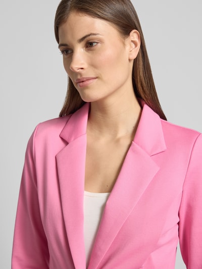 Modelka kobieca ma na sobie Regular Fit Blazer mit Viskose-Anteil Modell 'Kate' od ICHI, różowy kolor, struktura gładka, z kołnierzem z klapami, kieszenie z lamówką, zapięcie na guzik, elastyczna mieszanka materiałów z wiskozą; długość tyłu w rozmiarze S: 58 cm, szerokość w rozmiarze S: 43 cm, długość rękawa w rozmiarze S: 62 cm, zbliżenie górnej części ciała z przodu.