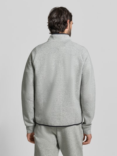 Männermodel trägt Regular Fit Pullover mit Logo-Print Modell 'Unstoppable' von Under Armour in Hellgrau, elastischer Material-Mix, Ganzkörperansicht Rückansicht.