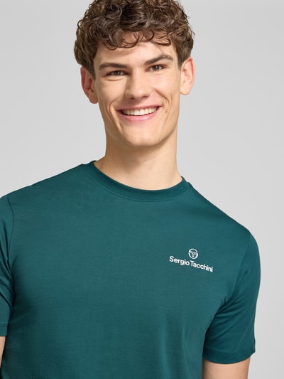 Männermodel trägt Regular Fit T-Shirt mit Logo-Print von SERGIO TACCHINI in Smaragdgrün, reine Baumwolle, Nahaufnahme Oberkörper.