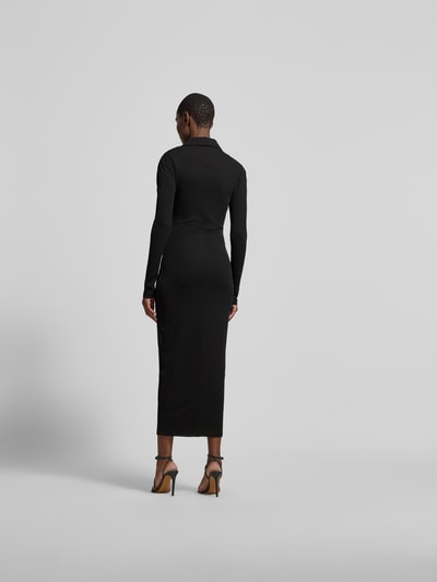 Frauenmodel trägt Hemdblusenkleid in Maxilänge von Nanushka, schmal geschnitten, Hemdblusenkragen, durchgehende Knopfleiste, langärmelig, Farbe Schwarz, Material glatt, Gesamtlänge 134 cm, Brustweite 40 cm, Ärmellänge 64 cm, Ganzkörperansicht Rückansicht.