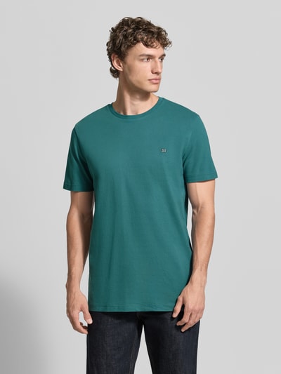 Männermodel trägt T-Shirt aus Baumwolle mit Rundhalsausschnitt von Christian Berg Men in Türkis, Regular-Fit, Label-Detail, Ganzkörperansicht von vorne