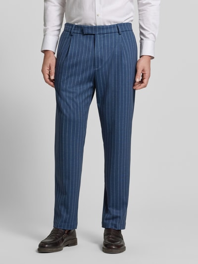 Mężczyzna nosi Slim Fit Anzughose mit Viskose-Anteil Modell 'Silvio' od CINQUE, niebieski z pionowymi białymi paskami, Ganzkörperansicht von vorne. Krój slim fit, elastyczna mieszanka materiałów z domieszką wiskozy, zaszewki, kieszenie z tyłu, zapięcie na haftkę i zamek, szerokość w rozmiarze 50: 48 cm, długość nogawki wewnętrznej w rozmiarze 50: 71 cm.