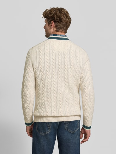 Männermodel trägt Strickpullover mit Woll-Anteil von MCNEAL in Creme mit Zopfmuster und gerippten Abschlüssen, Ganzkörperansicht Rückansicht. Rückenlänge Größe M: 71 cm, Ärmellänge Größe M: 74 cm, gerader Schnitt, V-Ausschnitt.