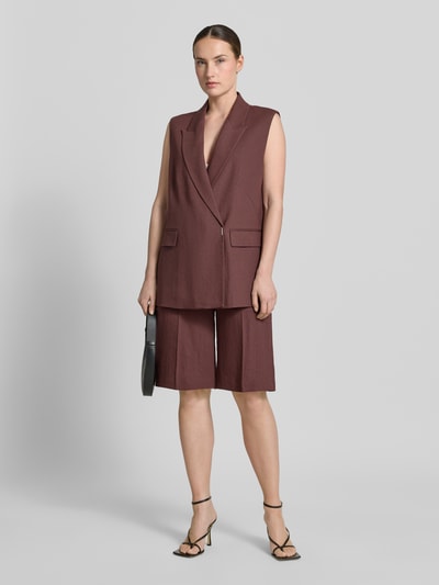 Vrouwenmodel draagt Regular Fit bermudashorts uit linnen-viscose-mix model 'TIANALA' van BOSS in mêlee twill, met labelapplicatie, riemlussen, haakjes- en ritssluiting, achterzakken en zijritszak, gemêleerde look. Ganzlichaamsaanzicht van voren.
