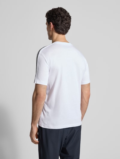 Męski model nosi Regular Fit T-Shirt mit Logo-Patch od EA7 Emporio Armani, biała bawełna, krój regular fit, widok całej sylwetki z tyłu.