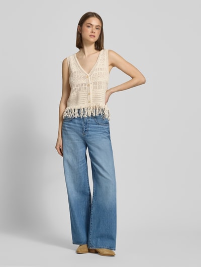 Frauenmodel trägt Regular Fit Weste aus Baumwoll-Mix Modell 'ALIX' von Only in Strickoptik mit Fransen, Strukturmuster, Ganzkörperansicht von vorne.