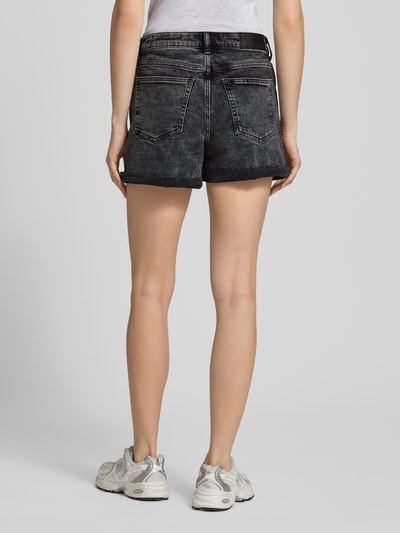 Frauenmodel trägt High Waist Jeansshorts mit Umschlag Modell 'MONI' von Noisy May aus Baumwoll-Elasthan-Mix, Regular-Fit, Eingrifftaschen, Schwarz, grobe Struktur, Bundweite 38 cm, Innenbeinlänge 9 cm, Ganzkörperansicht Rückansicht.