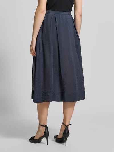 Frauenmodel trägt dunkelblauen Midirock mit seitlichem Nahtreißverschluss von Emporio Armani, Lyocell-Mix, A-Linie, Ganzkörperansicht Rückansicht.