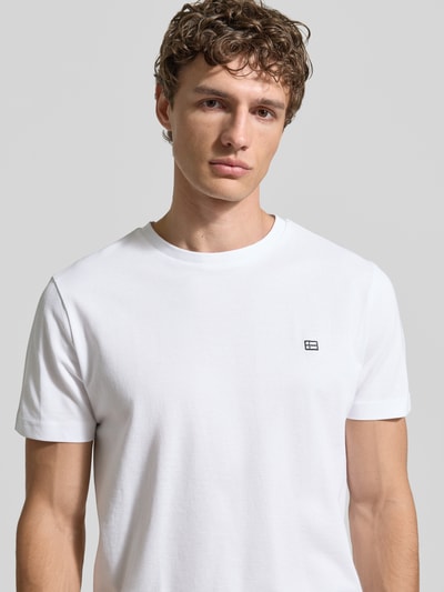 Männermodel trägt T-Shirt aus Baumwolle mit Rundhalsausschnitt von Christian Berg Men, Reine Baumwolle, Regular-Fit, Label-Detail, Nahaufnahme Oberkörper.