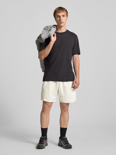 Männermodel trägt Shorts mit Logo-Stitching Modell 'ZANICA' von Ellesse, Baumwoll-Mix, entspannter Schnitt, helle Farbe, Ganzkörperansicht von vorne.