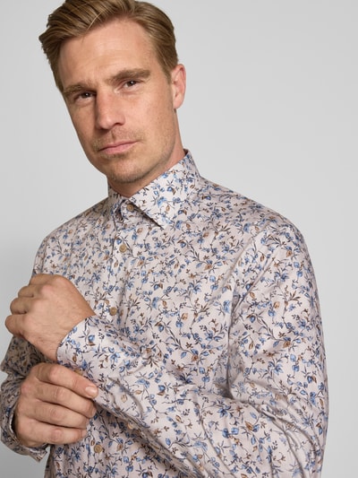 Männermodel trägt Modern Fit Businesshemd mit extra langem Arm von OLYMP, florales Muster in Beige, Blau und Braun, Nahaufnahme Oberkörper, Herren Businesshemd von OLYMP