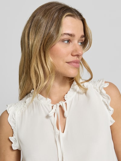 Frauenmodel trägt Regular Fit Blusentop aus reiner Viskose Modell 'ALBA' von Vero Moda, Optik: Unifarben, Rüschenkragen, Binde-Detail, Rüschen, V-Ausschnitt, Ärmelform: Ohne Ärmel, Ärmelabschluss: Rüschen, Material: Reine Viskose, Nahaufnahme Oberkörper.