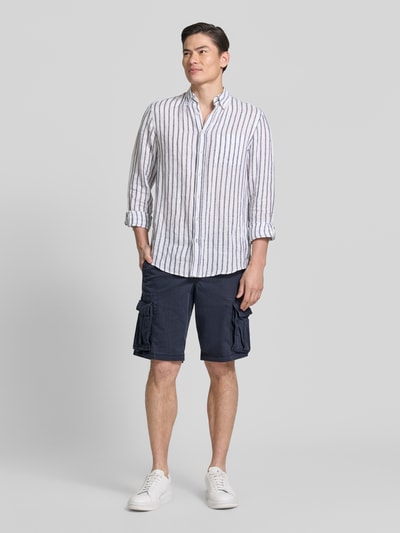 Männermodel trägt Shorts mit Cargotaschen Modell 'NEW 24' von GAP in Dunkelblau mit Regular Fit aus Baumwoll-Elasthan-Mix, Ganzkörperansicht von vorne