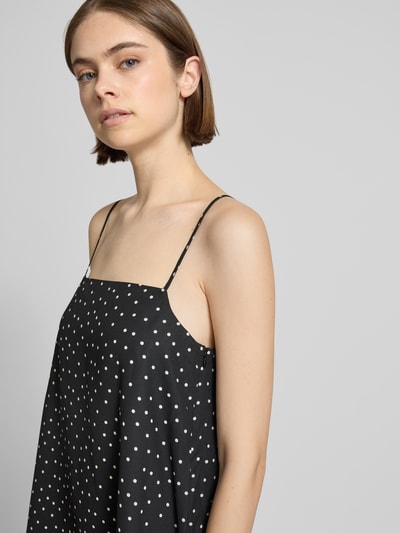 Frauenmodel trägt Minikleid im Allover-Look mit Spaghettiträgern von REVIEW aus schwarzem Satin, A-Linie, Nahaufnahme Oberkörper. Rückenlänge 70 cm, Brustweite 44 cm bei Größe S.