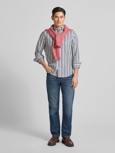 Męski model nosi Straight Fit Jeans aus reiner Baumwolle Modell 'DOVER' od Tommy Hilfiger, niebieski denim, 5 kieszeni, pełny widok z przodu.
