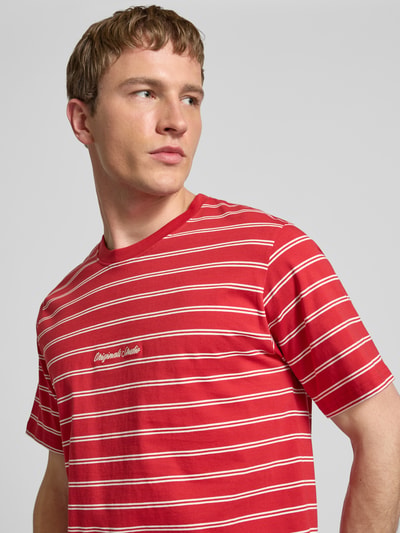 Mannenmodel draagt T-shirt met streepmotief en ronde hals van JACK & JONES, puur katoen, regular fit, stitching, ruglengte maat M 62 cm, detailopname bovenlichaam.