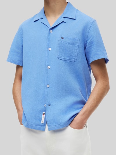 Männermodel trägt Regular Fit Freizeithemd aus Leinen-Baumwoll-Mix von Tommy Jeans in Optik: Unifarben, Logo-Stitching, Flammgarnstruktur, Nahaufnahme Oberkörper.
