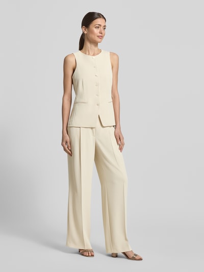 Vrouwenmodel draagt Weste mit Rundhalsausschnitt und Paspeltaschen van V by Vera Mont in beige, regular fit, materiaal-mix met stretch, knoopsluiting, paspelzakken, ruglengte bij maat 36: 60 cm, full body voorkant.