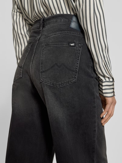 Frauenmodel trägt Wide Fit Jeans im 5-Pocket-Design Modell 'Luise' von Mustang, schwarze Denim-Struktur, Nahaufnahme Rückansicht. Elastischer Baumwoll-Mix.