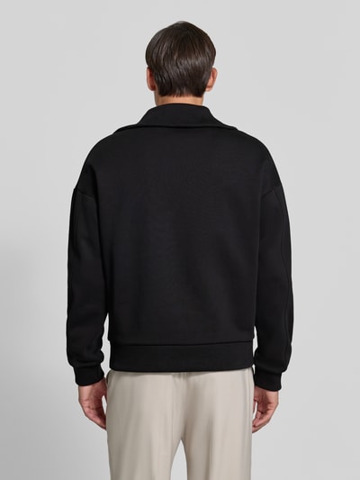 Männermodel trägt schwarzes Regular Fit Sweatshirt aus Baumwoll-Mix mit Troyer-Kragen von DRYKORN, dezentes Logo-Stitching, Rückenansicht, Produkt entspricht Kontextangaben. Ganzkörperansicht Rückansicht.