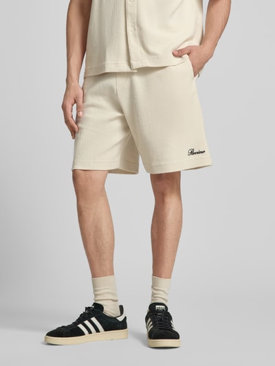 Männermodel trägt Shorts mit Label-Stitching von REVIEW aus Baumwoll-Mix, Regular-Fit, Strukturmuster, Nahaufnahme Oberschenkel.